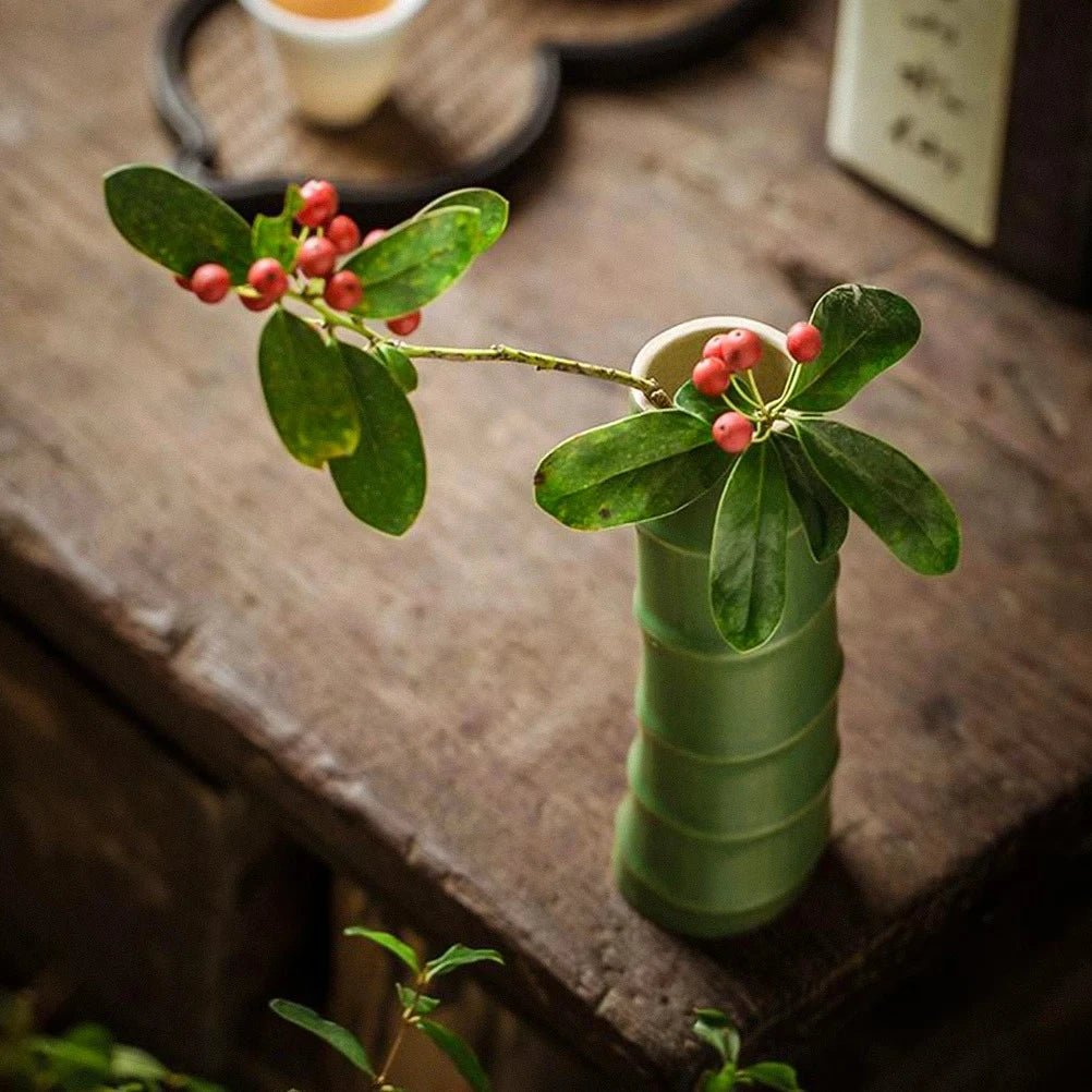 Small Green  with greenery inside on a wooden table