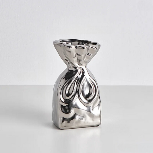 Small Silver Vase on a gray table in front of a white background