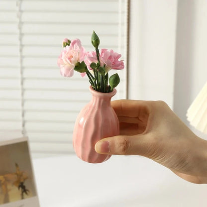 Person holding a Small Vase in Rose with flowers inside