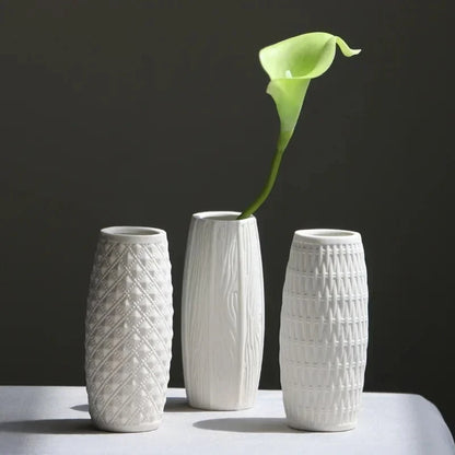 Three Small White Vases with a green flower inside