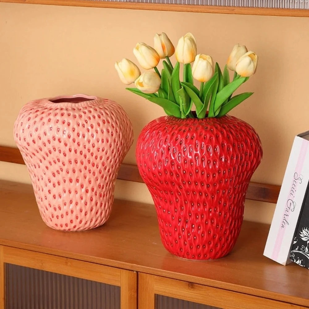 Two Strawberry Vases with flowers inside on a wooden shelf