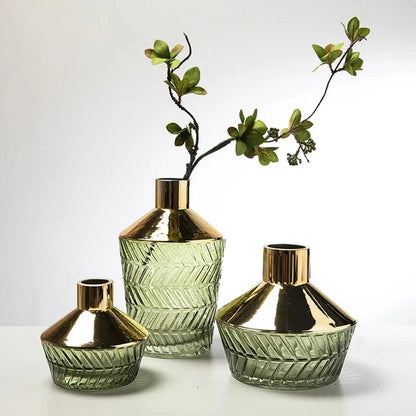 Three Vases With Gold Rims on a white surface with greenery inside