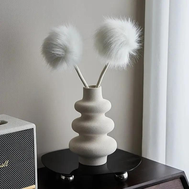 White Bud Vase with white decoration inside on a black podium