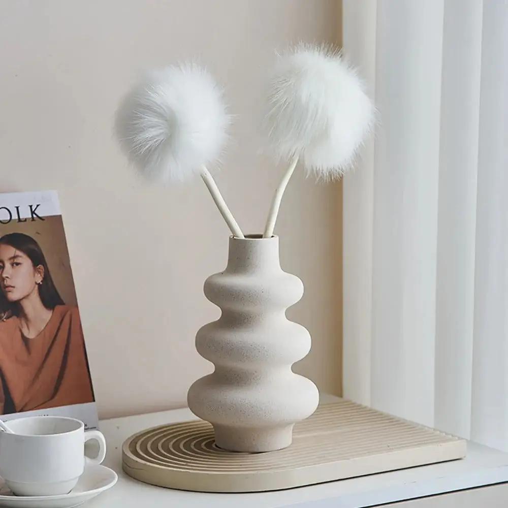 White Bud Vase with white decoration inside on a beige tray