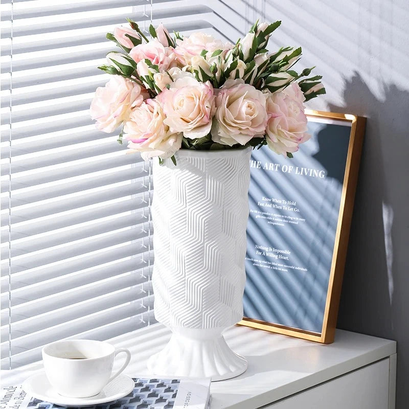 White Cylinder Vase on a white shelf in front of an image frame next to a mug