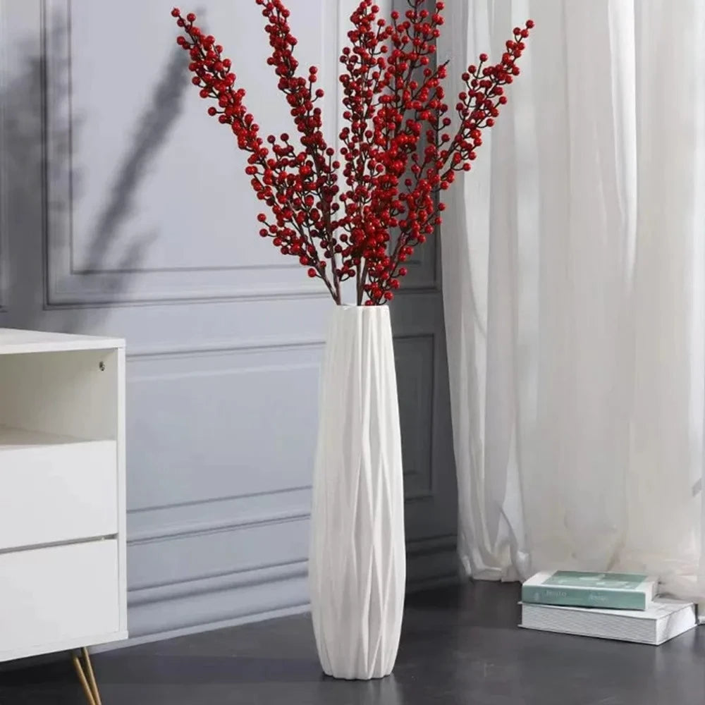 White Floor Vase with red plants inside on a gray floor