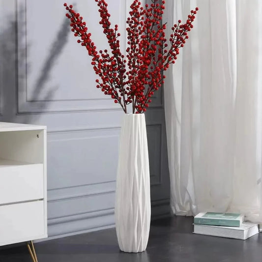 White Floor Vase with red plants inside on a gray floor