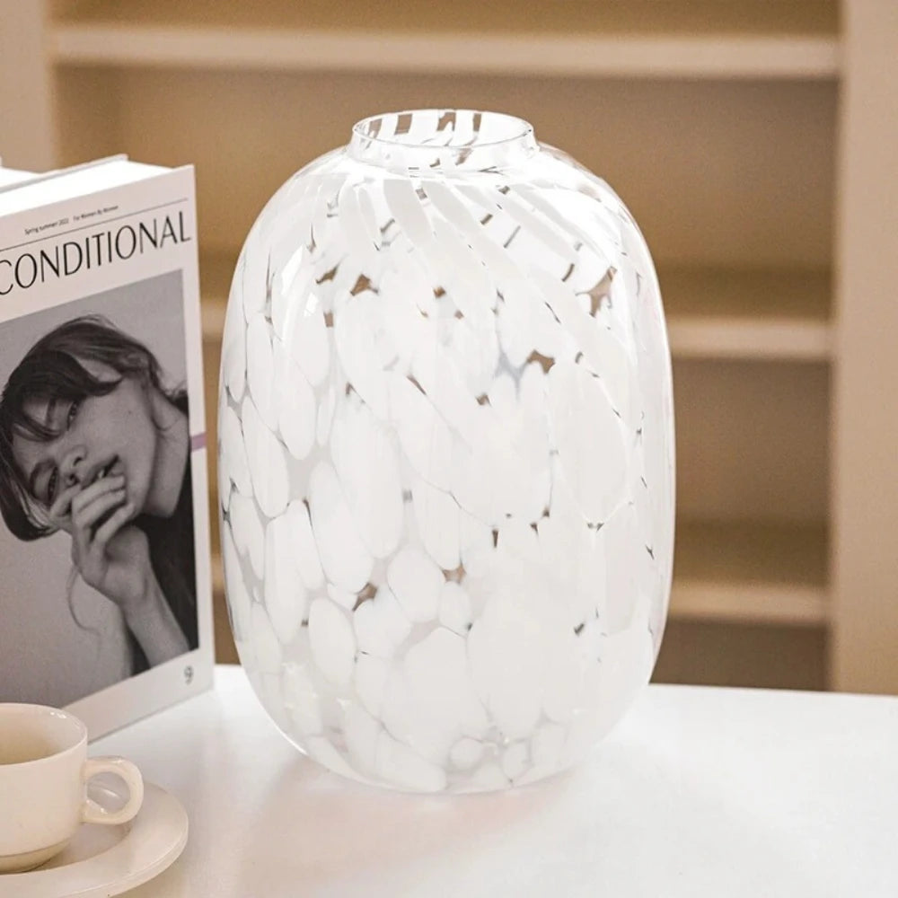 Large White Glass Vase on a white surface next to a book