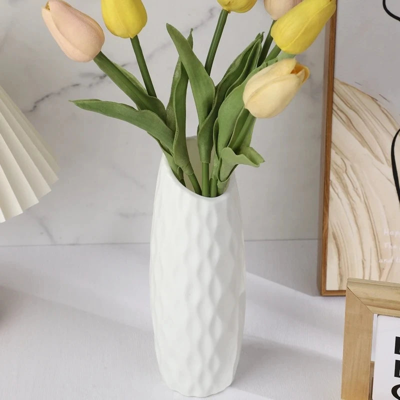 White Plastic Vase on a white surface with yellow flowers inside