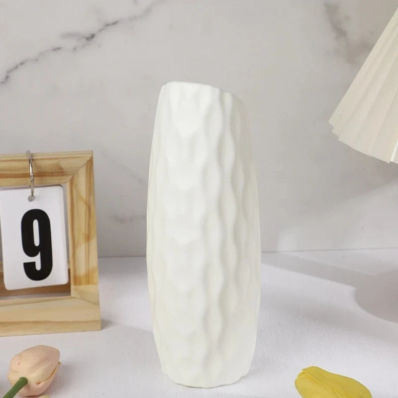 White Plastic Vase on a white surface next to a calendar