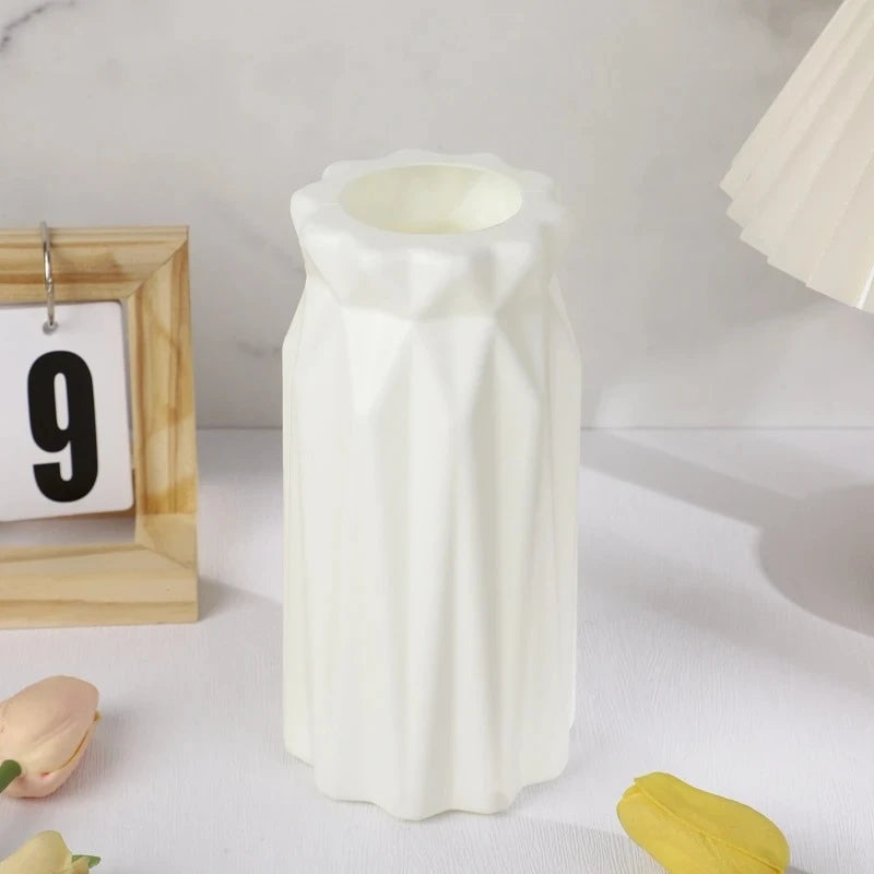 White Plastic Vase on a blank surface next to a calendar