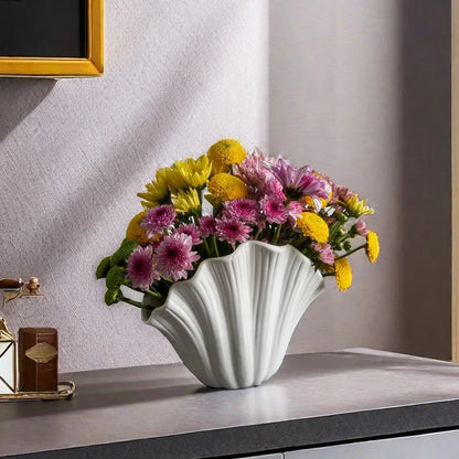 White Rose Vase with pink and yellow flowers inside on a gray shelf