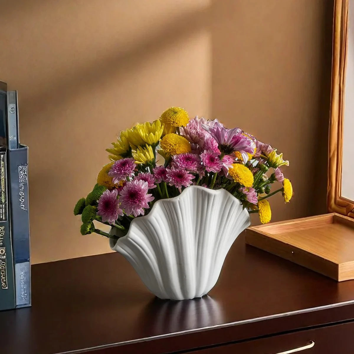 White Rose Vase with pink and yellow flowers on a brown shelf next to a tray