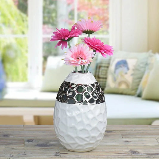White and Silver Vase on a wooden table with pink flowers inside
