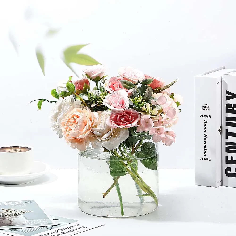 Wide Glass Cylinder Vase with flowers inside on a white surface 