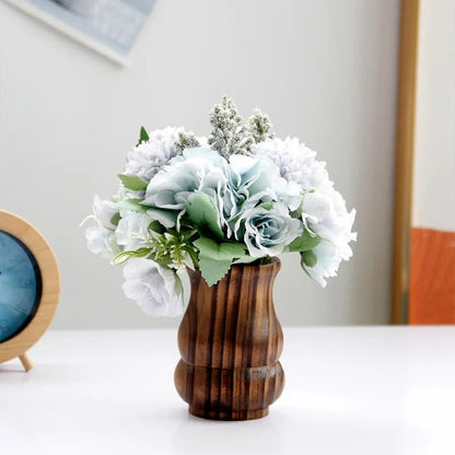 Wood Vase with flowers inside on a white table