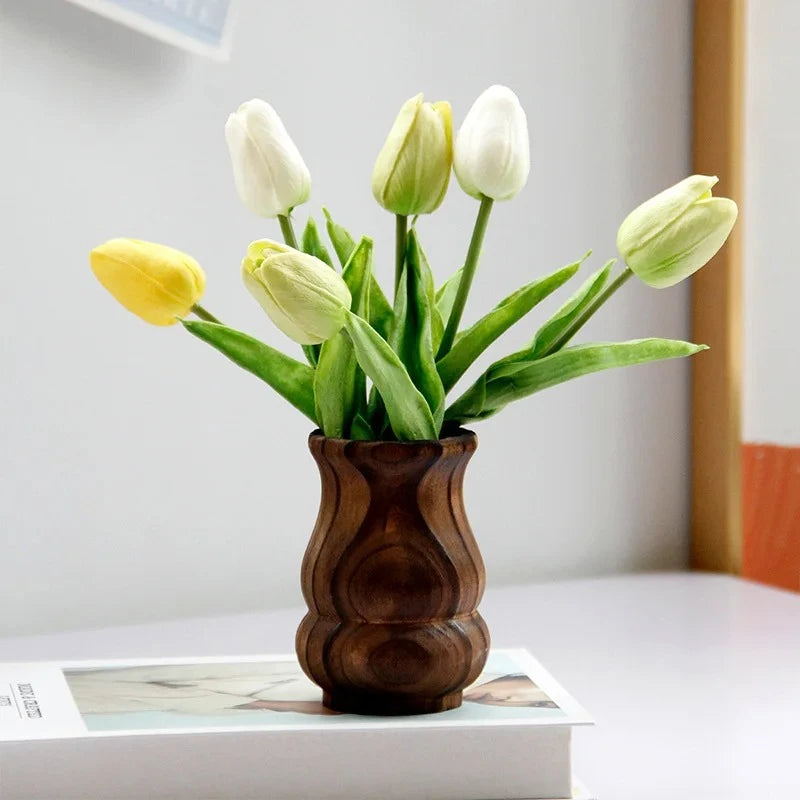 Wood Vase with yellow tulips inside standing on a book